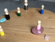 Familieopstelling met houten poppetjes en edelstenen op een houten tafel.