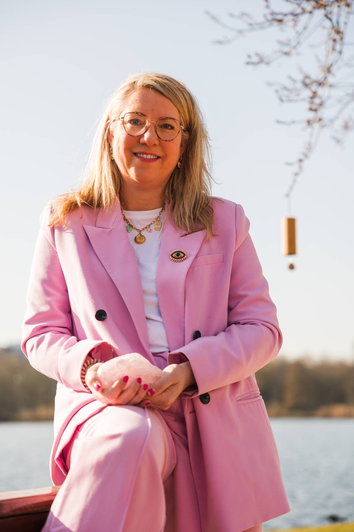 Sandy Vivaldi, holistisch therapeut, in het bos met in haar handen een rozenkwarts.