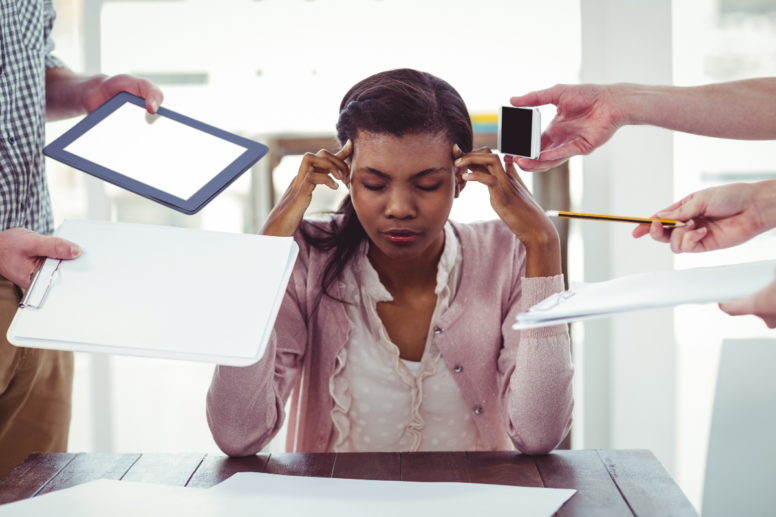 Een vrouw die van de stress haar handen op haar hoofd zet. Van alle kanten komen taken voor haar. Ze voelt zich voor alles en iedereen verantwoordelijk.